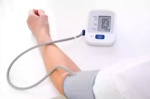 fish intake reduces blood pressure- a person checking his blood pressure with a sphygmomanometer.